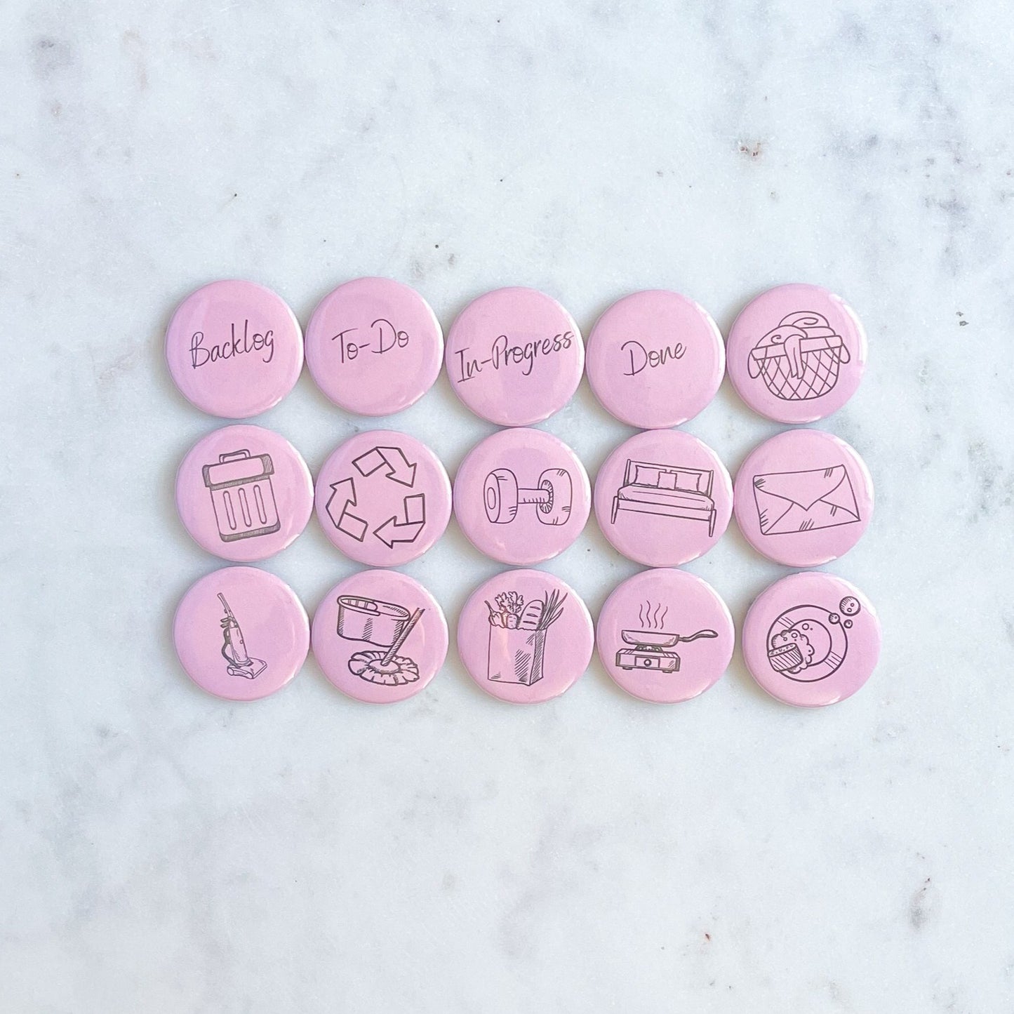 Set of 15 magnets with images representing different chores on a pink background. The magnets or on a marble table or surface